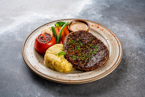 fillet steak with tomato served in a dish isolated on dark background side view food