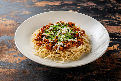spaghetti bolognaise pasta served in a dish isolated on dark background side view food