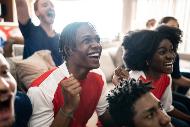 istock Sports fans celebrating while watching a match at home 1410130209