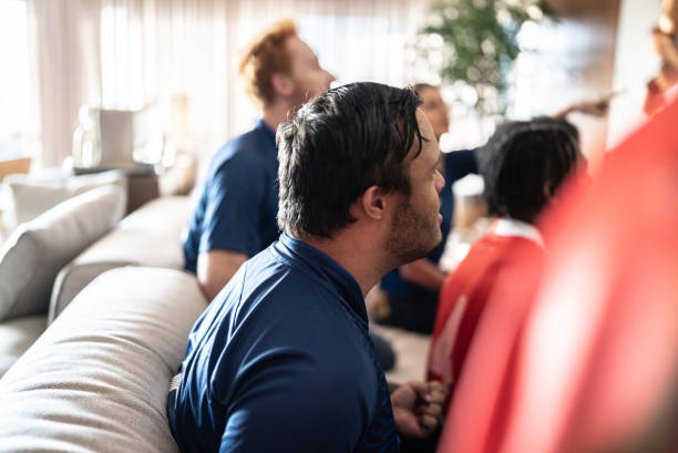 istock Special needs young man watching soccer with friends at home 1410130227