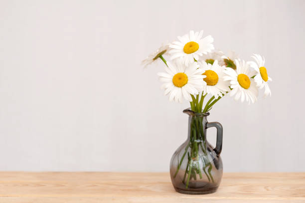 istock Bouquet of white daisies in a vase on the table. 1410130579
