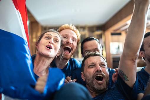 French fan friends watching sports match and celebrating at a house