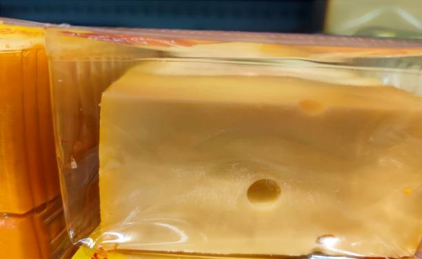 istock Plastic container with a large block of cheese in it is being sold without visible marks or brands on a supermarket shelf 1410132802