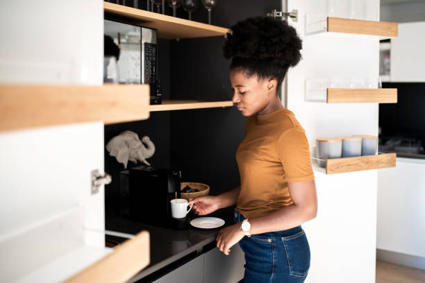 istock Woman preparing a fresh coffee with a coffee maker machine 1410132845