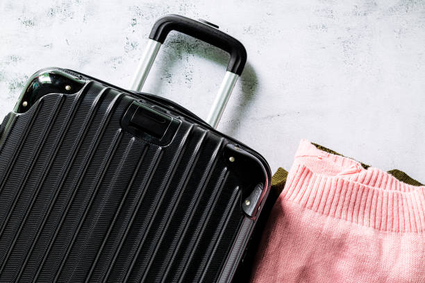 istock Suitcases and sweaters,Open suitcase with clothes, passport and bag on floor 1410136764