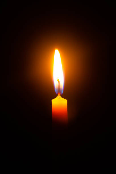 istock macro candle,Close up single candle light and flame on black background 1410136940