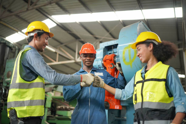 três diversos engenheiros e trabalhadores da indústria pesada multicultural em uniforme na fábrica de aço. - turning list - fotografias e filmes do acervo