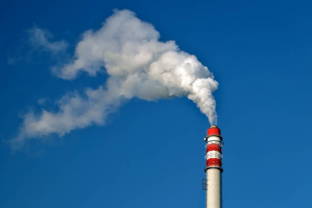 il fumo esce dal camino contro il cielo blu - toxic substance fumes environment carbon dioxide foto e immagini stock