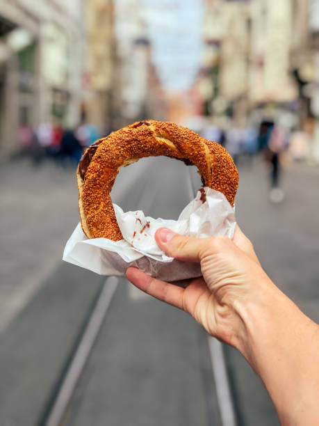 istock Turkish bagel SIMIT in white hand on street 1410143695