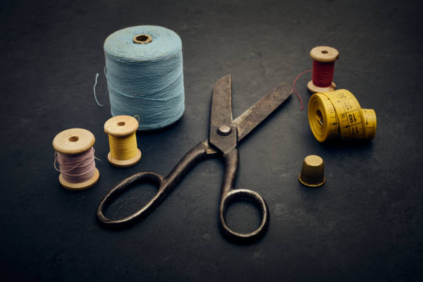 istock Old sewing and tailoring supplies, scissors, thread, tape measure, thimble 1410145278