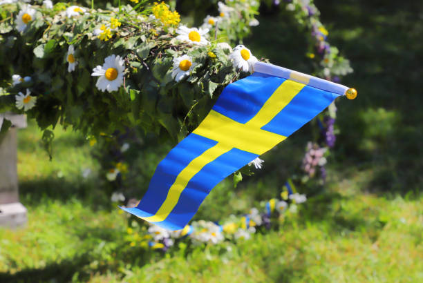 Midsummer pole Traditional midsummer pole with Swedish flag awaits the rising ceremony. swedish summer stock pictures, royalty-free photos & images