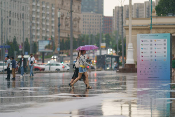 Wet people in rainy day in city center at summer. stock photo