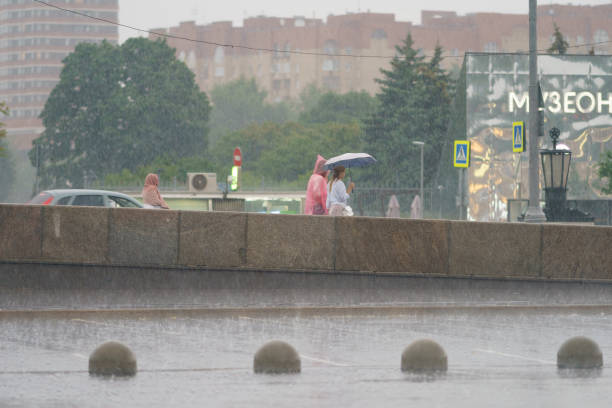 夏の市内中心部の雨の日に濡れた人々。 - two lane highway 写真 ストックフォトと画像