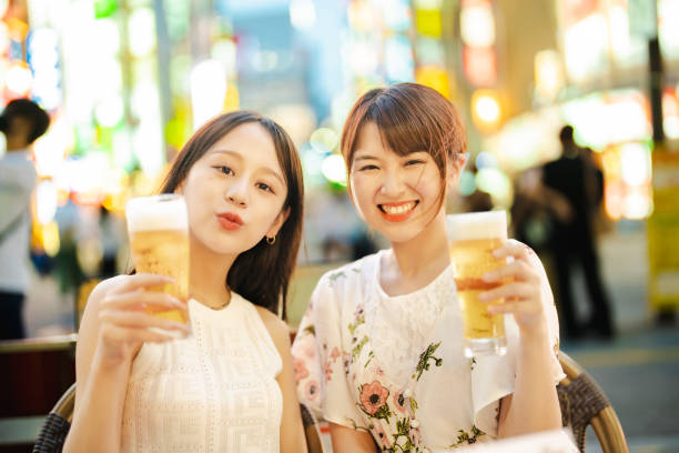 deux femmes avec un verre de bière - japan tokyo prefecture city women photos et images de collection
