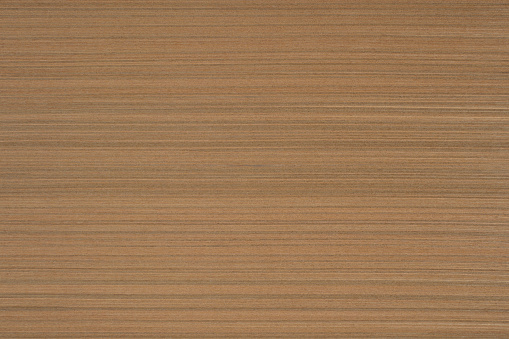 High angle view of a flat textured wooden board backgrounds. It has a beautiful nature and abstractive pattern. A close-up studio shooting shows details and lots of wood grain on the wood table. The piece of wood at the surface of the table also appears rich wooden material on it. The wood is light brown color with darker brown lines and pattern on the bottom. Flat lay style.