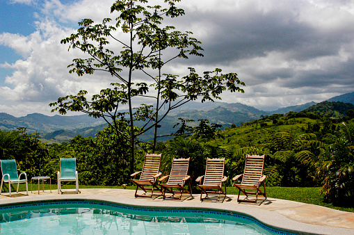 Beautiful pool and resort in the Costa Rican rainforest landscape, surrounded by hills in this panoramic shot near Dominical.