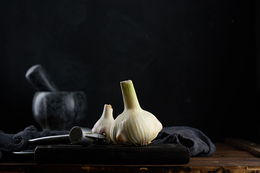 White garlic fruit on a black wooden board, spice