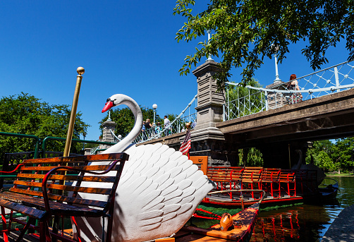 Boston, Massachusetts, USA - July 19, 2022: Close-up of the white swan cockpit on an empty swan boat at its dock next to the pedetrian bridge in the Boston Public Garden.