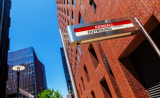 Cambridge, Massachusetts, USA - July 19, 2022:  Kendall Square sign for its MBTA Red LIne subway station amid nearby buildings. Kendall Square is an internationally recognized innovation distirct because of its high concentration of entrepreneurial startups. It is adjacent to the Massachusetts Institute of Technology (MIT) and has about 50,000 people who work in the area on a daily basis.