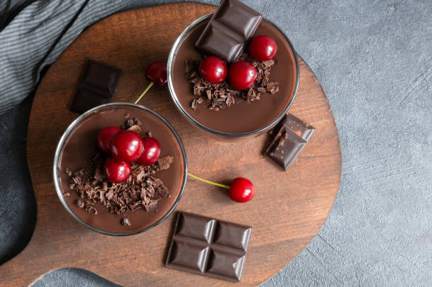 schokoladen-kakaopudding mit sauerkirsche, mousse im glasbecher auf rustikalem tisch, supangle - sour cherry stock-fotos und bilder
