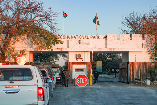 Von Lindequist Gate at Etosha National Park in Kunene Region, Namibia , with car number plates visible as well as people at the gate.
