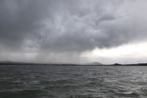 Lake Sevan in cloudy weather, with storm clouds and mountains in the background