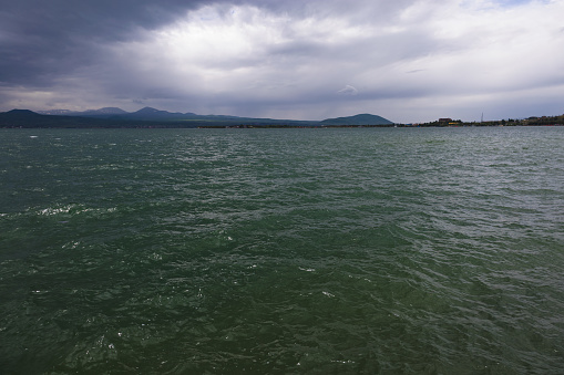 Lake Sevan in cloudy weather, with storm clouds and mountains in the background