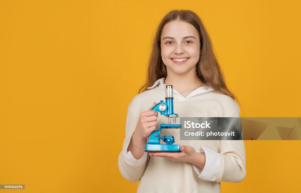 cheerful child with microscope on yellow background cheerful child with microscope on yellow background. Back to School Stock Photo