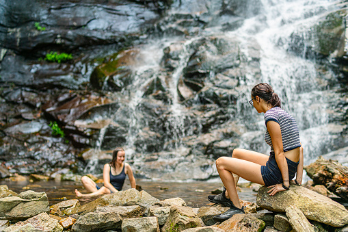 Two teenage girls are sitting at the bottom of Glen Onoko waterfall, Jim Thorpe, PA.