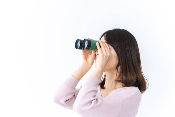 Young woman looking into the distance with binoculars