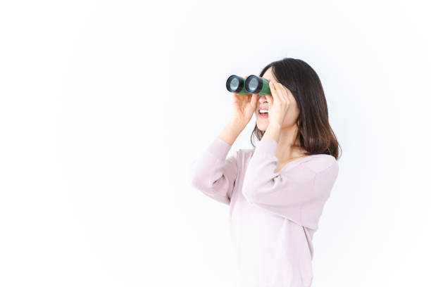 istock Young woman looking into the distance with binoculars 1410170316