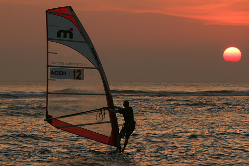 Gothenburg, Sweden - October 10 2021: Kiteboarders kitesurfing in the sunset by a beach .