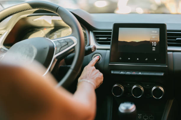 istock woman pressing the automatic start button on her car 1410177815