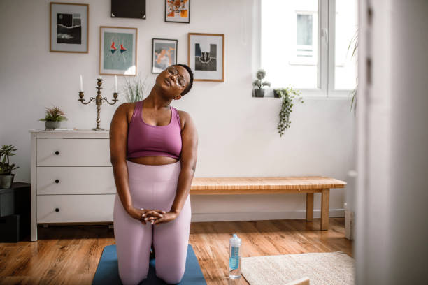 istock Young woman doing neck stretching exercises at home 1410180959