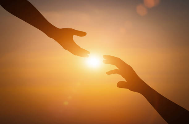 istock Silhouette of reaching, giving a helping hand, hope and support each other over sunset background. 1410181875
