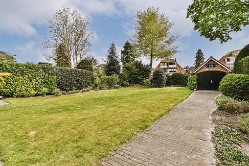 The backyard of the house with a large green lawn under the blue sky