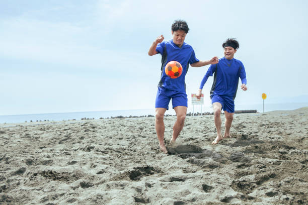 istock Beach  football players challenging for ball during match 1410193193