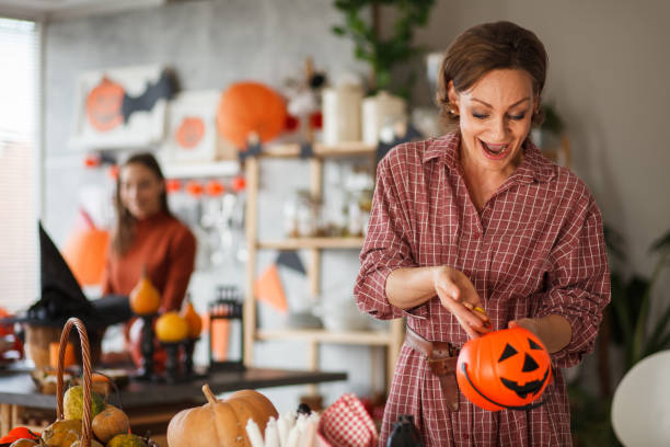 istock Woman preparing candy in Jack o' lantern bucket for Halloween 1410195446