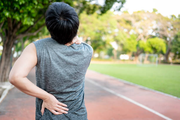 istock Spine pain. Man holding his neck and back during doing exercise 1410198316