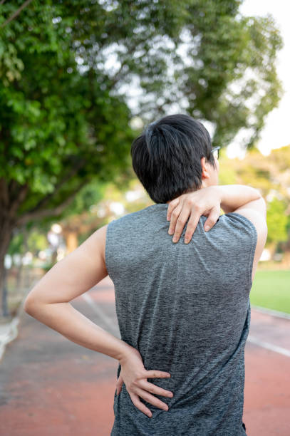 istock Spine pain. Man holding his neck and back during doing exercise 1410198321
