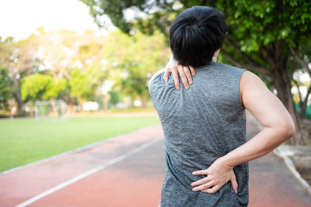 istock Spine pain. Man holding his neck and back during doing exercise 1410198327