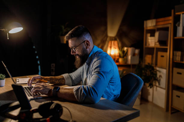 istock Businessman staying late at the office, typing data on laptop 1410200297