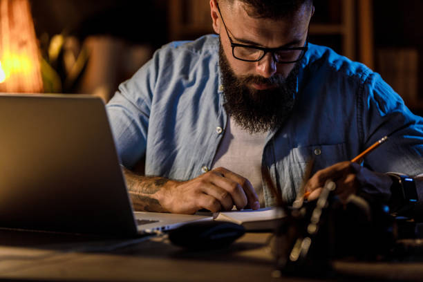 istock Lefthanded businessman writing notes and ideas when working at his desk 1410200307