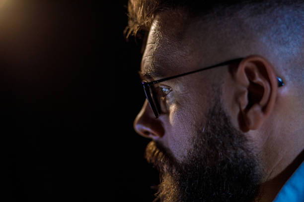 istock Profile view of hipster businessman looking at the screen while working late 1410200357