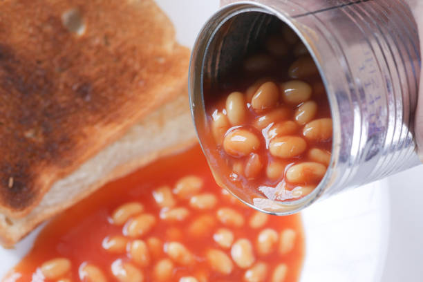 Tasty baked beans pouring from a can container Tasty baked beans pouring from a can container, selective focus canned food stock pictures, royalty-free photos & images