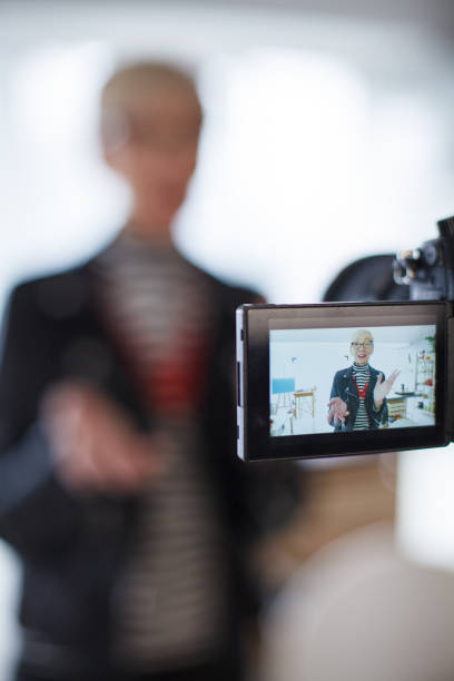 istock Mature vlogger gesturing while filming a video and talking to the camera 1410201935