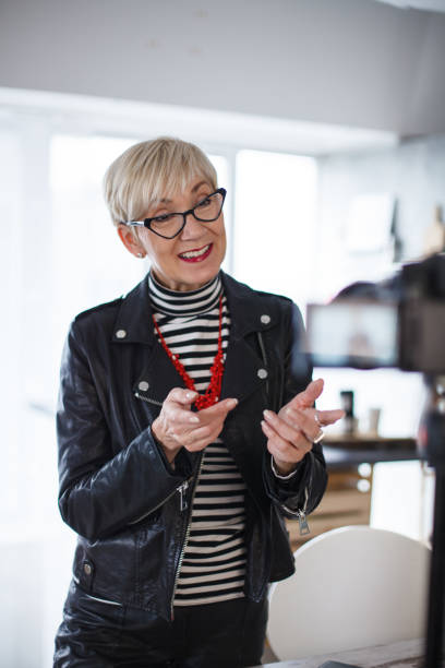 istock Charming mature woman filming a video, talking to camera and gesturing 1410201938