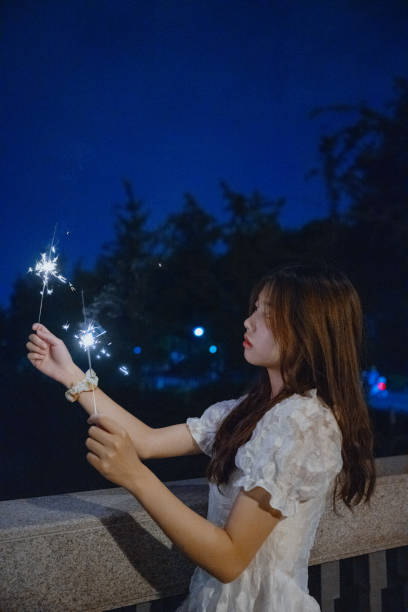 istock Asian girls playing fireworks at night 1410202050