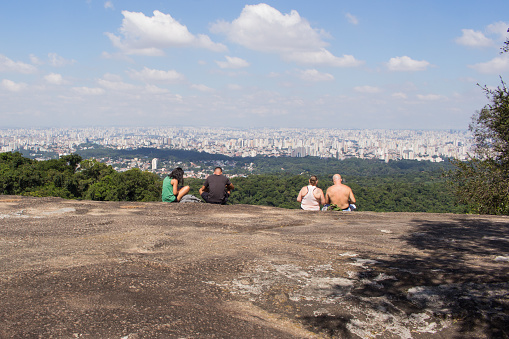 Sao Paulo, SP, Brazil - April 15, 2022: The sad irony of people having made an effort of kilometers uphill to reach this wonderful landscape to watch their cell phones. Society enslaved by technology.