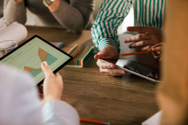 istock Cut out shot of unrecognizable business people analyzing data via digital tablets 1410202903